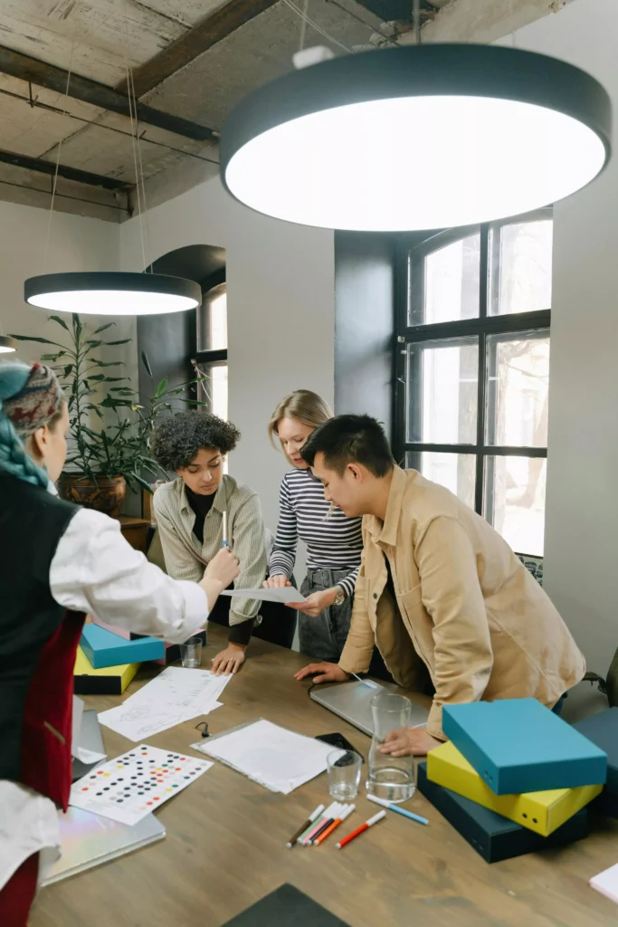 Team collaborating around a table reviewing documents in a modern office space