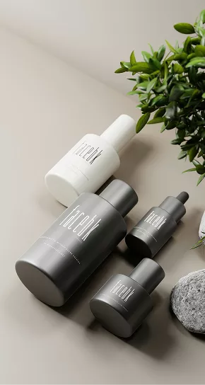 Top view of various grey and white cosmetic bottles with green leaves.