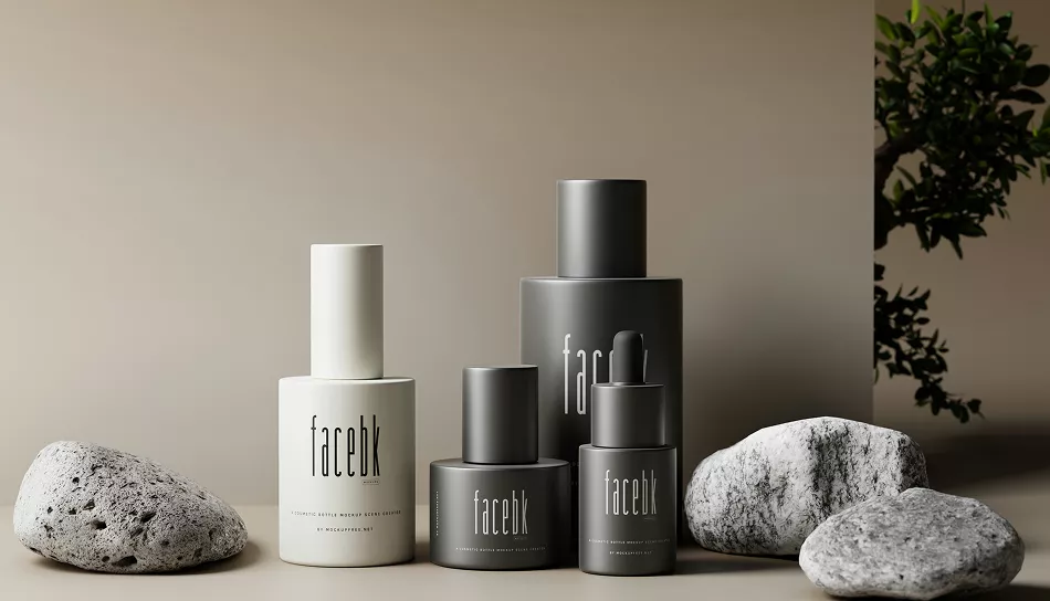 Minimalist skincare bottles in neutral gray and white packaging arranged with smooth stones and greenery on a beige background, creating a calm, modern aesthetic.
